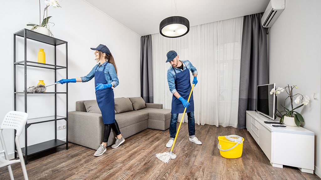 Two Happy Tide cleaners mopping and dusting a living room